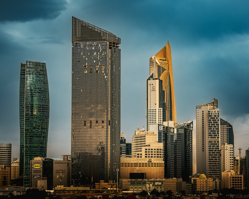 Modern skyline of Kuwait City at sunset, representing a safe and vibrant travel destination.