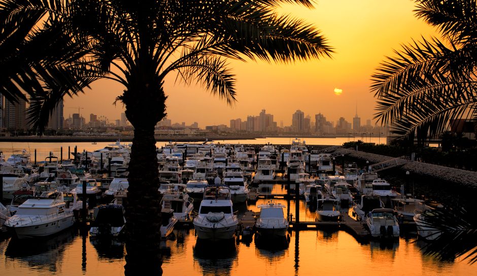 Iconic Kuwait Towers against a vibrant sunset sky, showcasing Kuwait City's modern architecture.