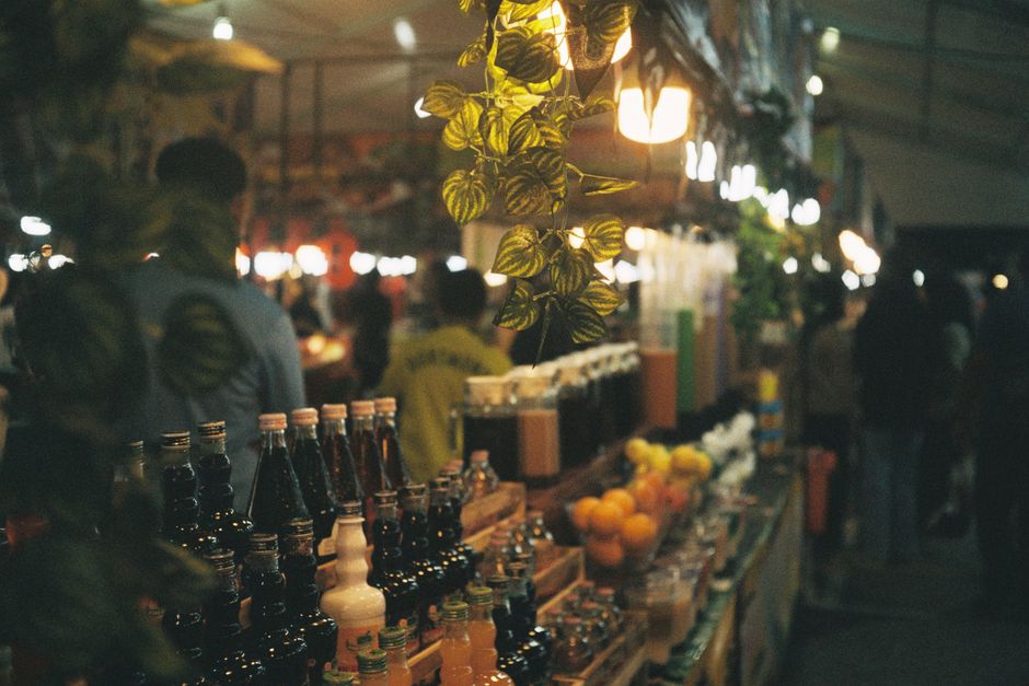 Vibrant night market scene in Malaysia with various food stalls and local people