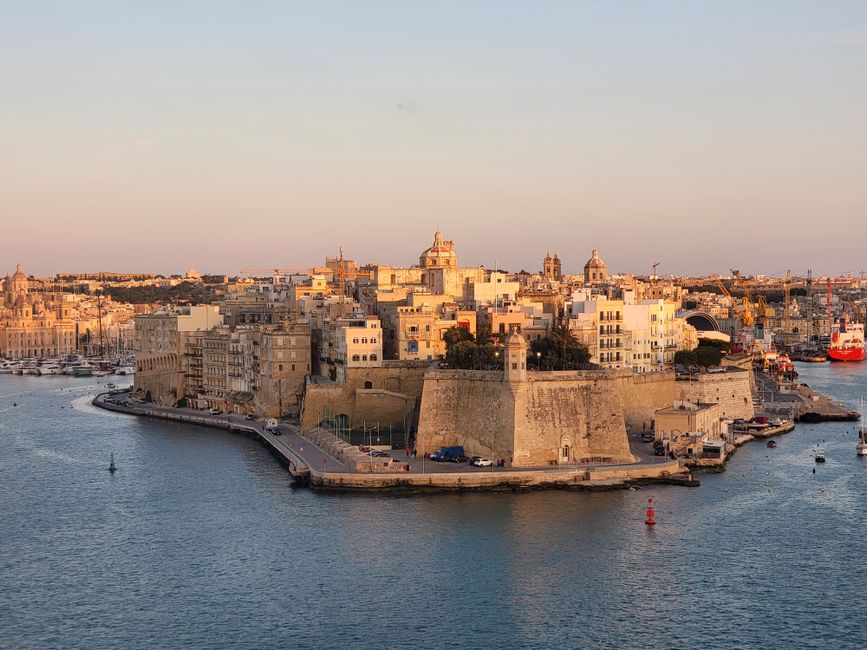 Panoramic sunset view of Valletta, Malta, showcasing historic buildings and the Grand Harbour