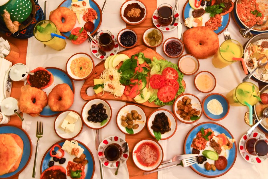 A vibrant spread of traditional Maltese dishes including pastizzi, ftira, and local wine on a table in Malta.