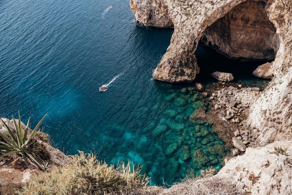 Tour boat sailing in the crystal clear turquoise waters of Blue Lagoon, Comino, Malta