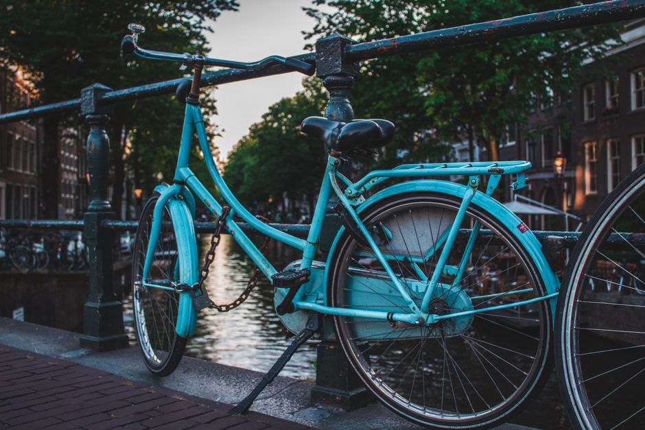 Bicycles parked along a scenic canal in Amsterdam, Netherlands