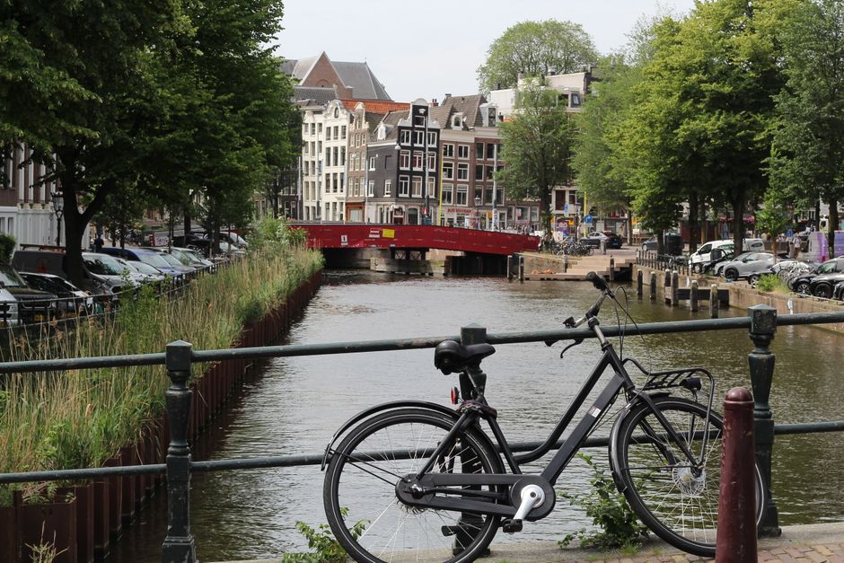 Vibrant canal street in Amsterdam, Netherlands, showcasing historic architecture and lively atmosphere