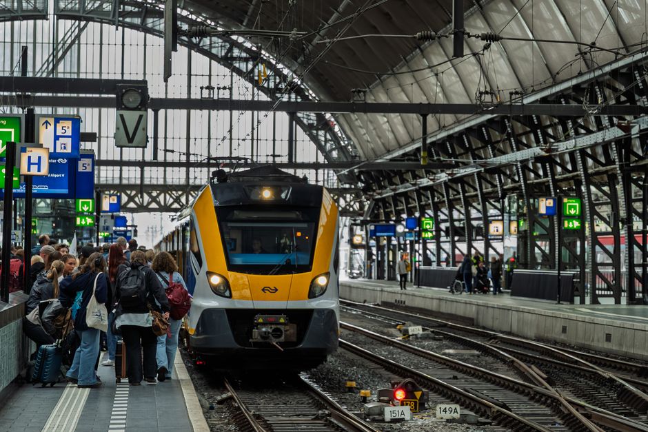 Modern train station platform in the Netherlands with a train arriving