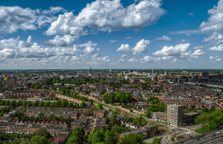 A picturesque Dutch landscape under a sky showing both sunshine and clouds, representing typical Netherlands weather.