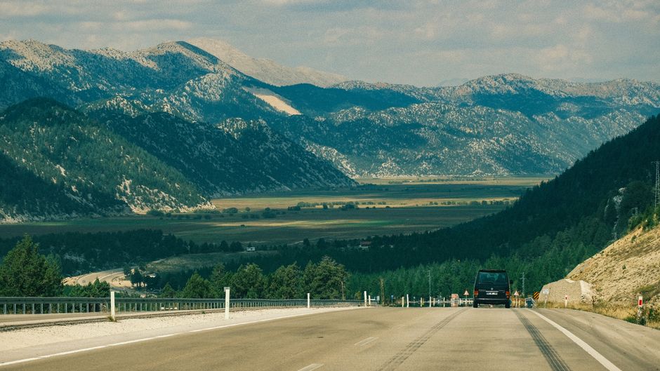 Scenic road winding through mountains in North Macedonia with a digital map overlay