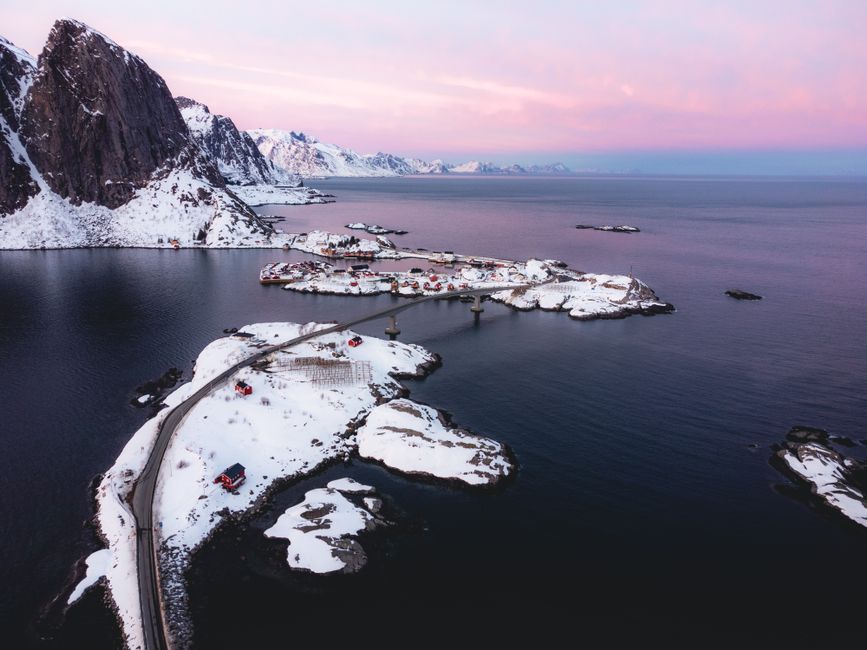 Traditional red rorbuer cabins by the water in Lofoten, Norway at sunset