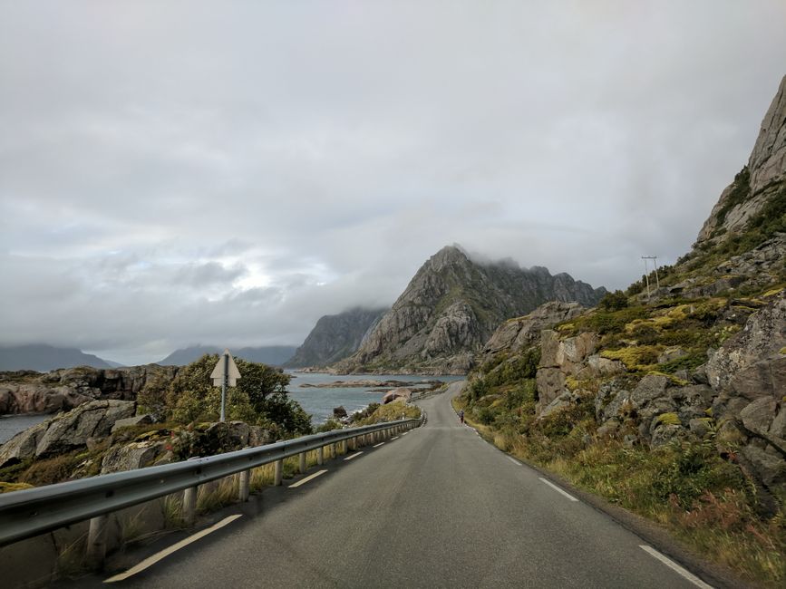 Car driving on a scenic road along a fjord in Norway