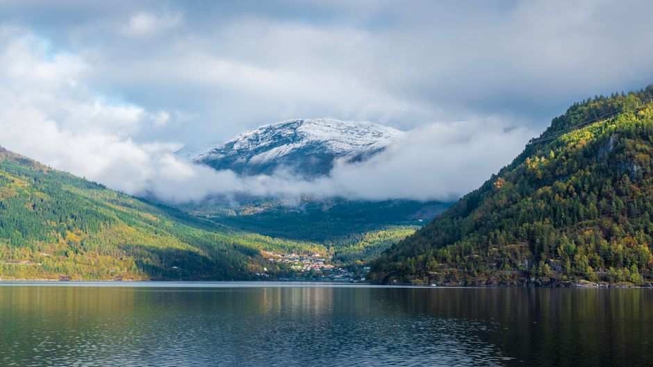 Airplane flying over majestic Norwegian fjords, symbolizing air travel in Norway