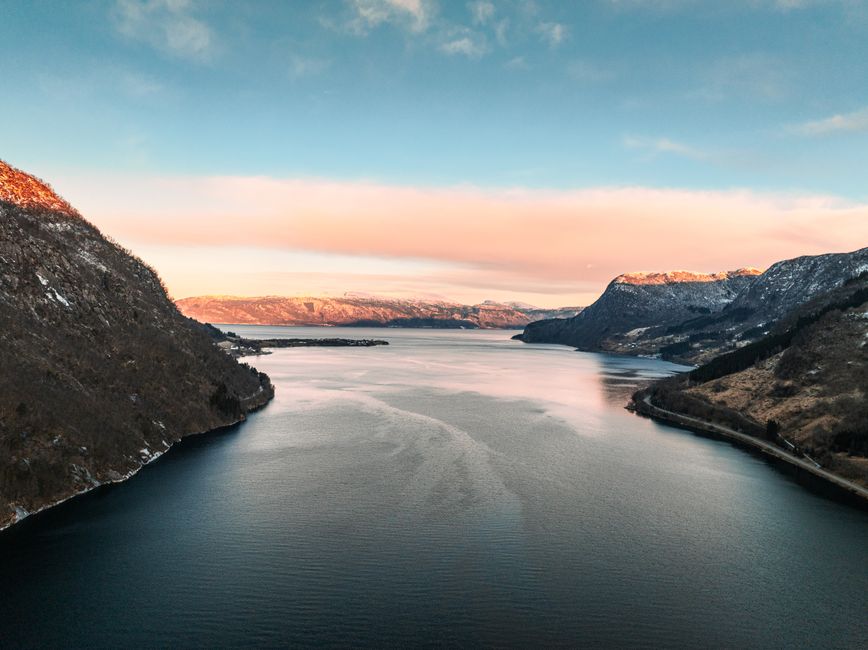 Traveler enjoying a stunning Norwegian fjord landscape, symbolizing peace of mind with Norway travel insurance