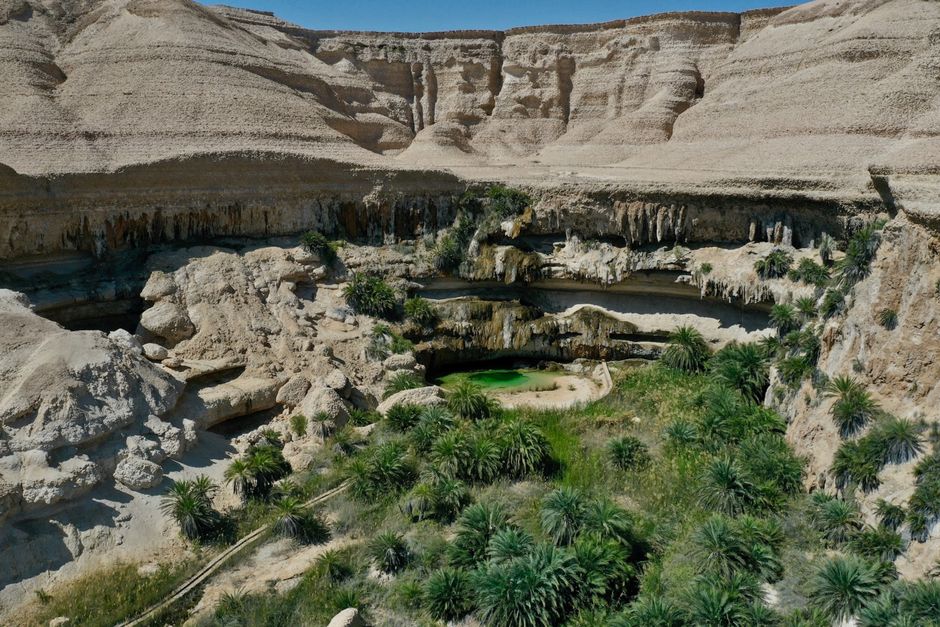 Turquoise pools and rocky cliffs of Wadi Shab in Oman, inviting adventure