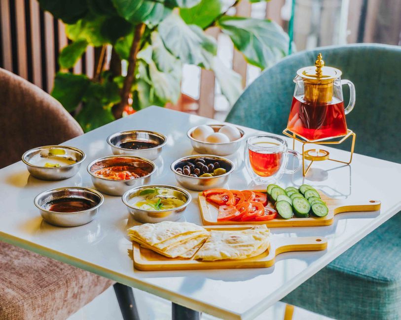 A vibrant spread of traditional Omani dishes including Shuwa, Majboos, and fresh fruits, served on a low table in Oman.