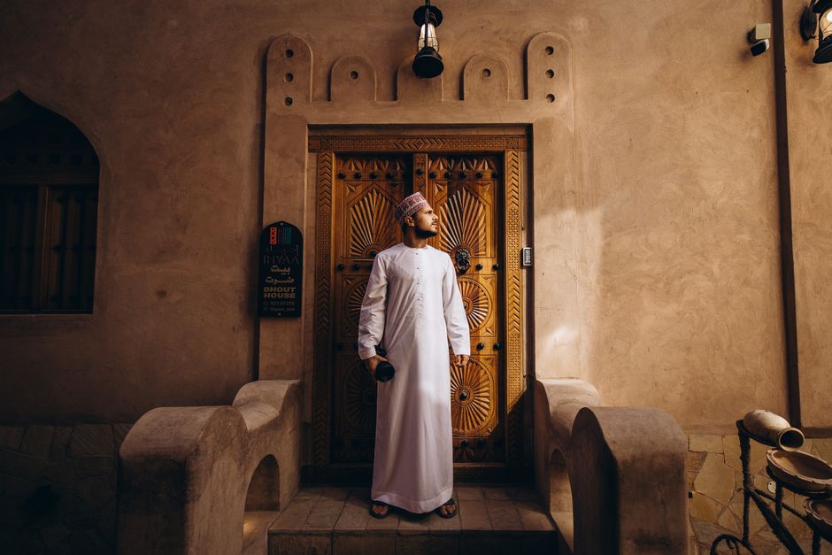 Traveler in lightweight, modest clothing exploring a vibrant souk in Muscat, Oman, ready for the warm weather.