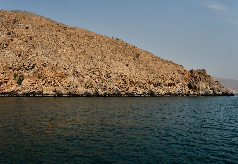 Stunning panoramic view of Oman's diverse landscapes, showcasing mountains and desert meeting the sea.