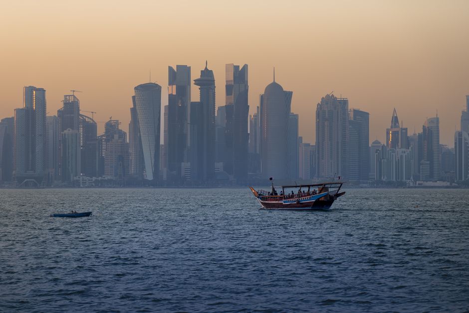 Doha skyline at sunset with an overlay of a digital map showing navigation routes in Qatar