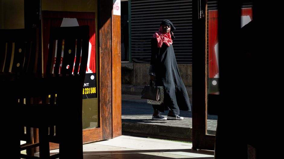 Woman wearing a modest outfit and scarf walking through Souq Waqif market in Doha, Qatar