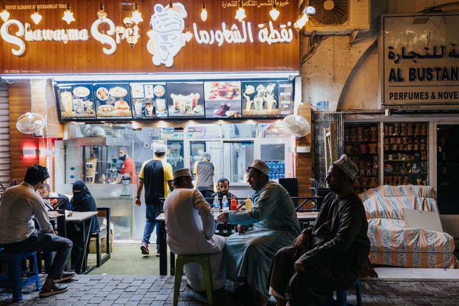 A vibrant scene at Souq Waqif in Doha, Qatar, with people browsing traditional goods and spices.