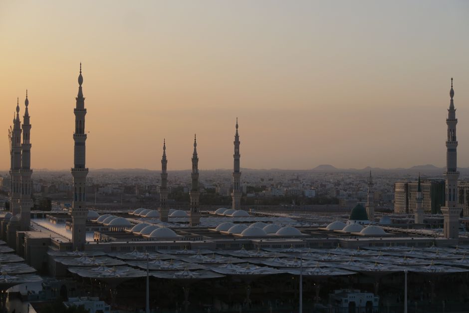 Panoramic view of diverse landscapes in Saudi Arabia, showcasing mountains, desert, and modern architecture.