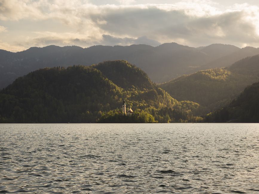 Travel backpack with Lake Bled and Julian Alps in Slovenia in the background