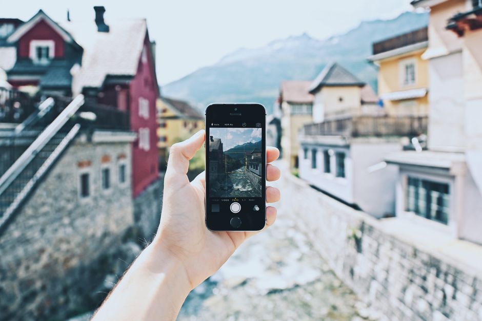 Traveler holding a mobile phone in Slovenia with a scenic background