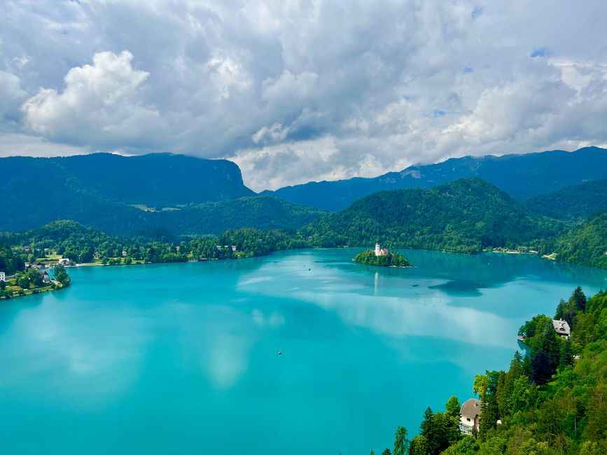 Travel insurance policy documents on a map of Slovenia with a scenic Julian Alps mountain backdrop