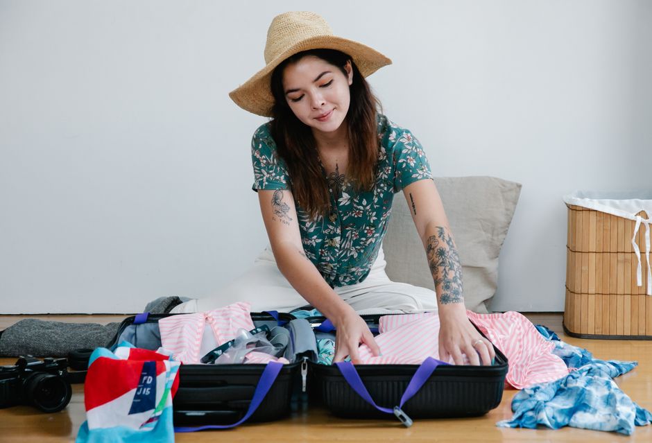 Traveler organizing a suitcase with essential items for a trip to South Korea