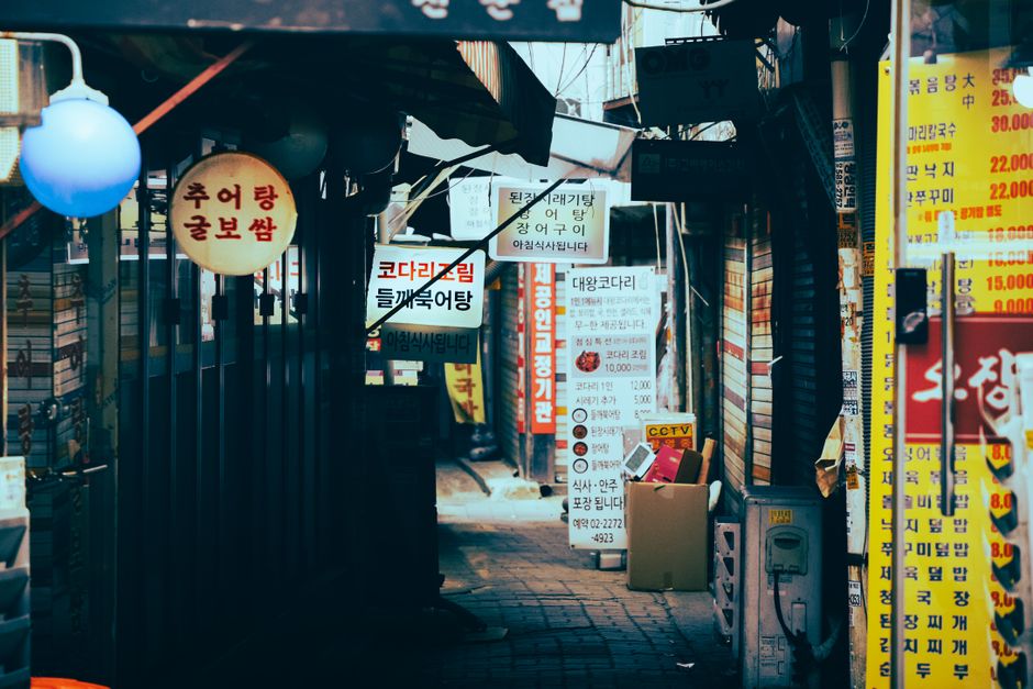 A bustling Myeongdong shopping street in South Korea with bright signs and people