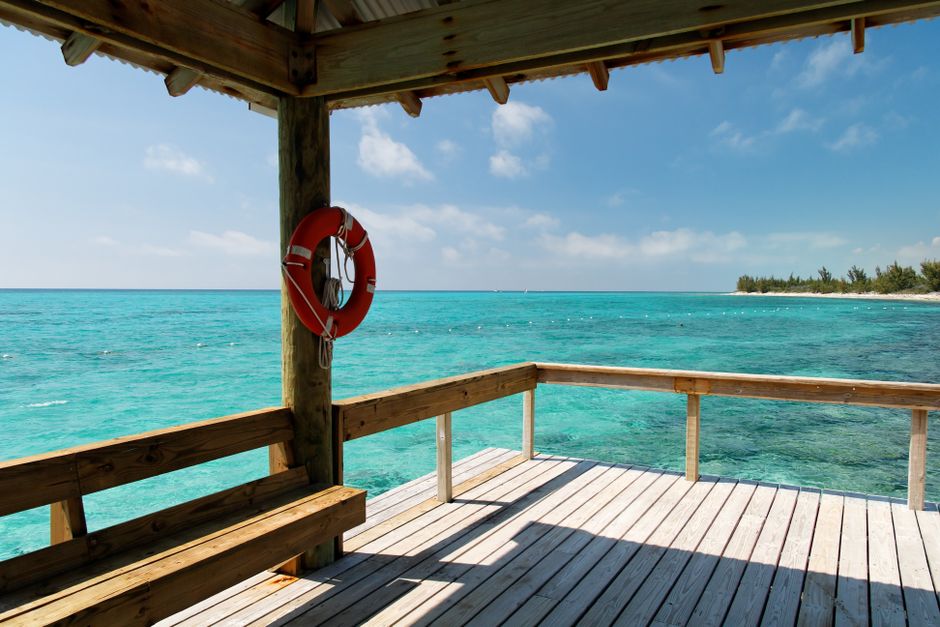 A stunning vibrant beach in the Bahamas with clear turquoise water and white sand, inviting travelers to explore.
