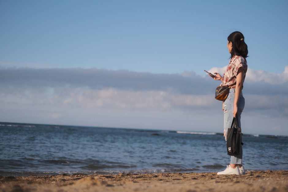 Tourist happily using a smartphone on a beautiful beach in the Bahamas