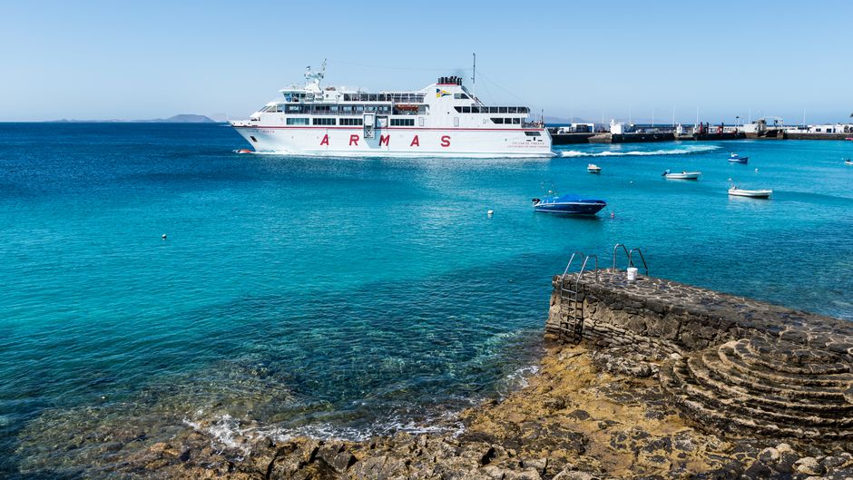 A vibrant Bahamas Ferries boat approaching the pink sand beach of Harbour Island, Bahamas.