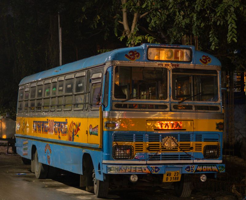 A vibrant jitney bus in Nassau, Bahamas, driving along a scenic street.