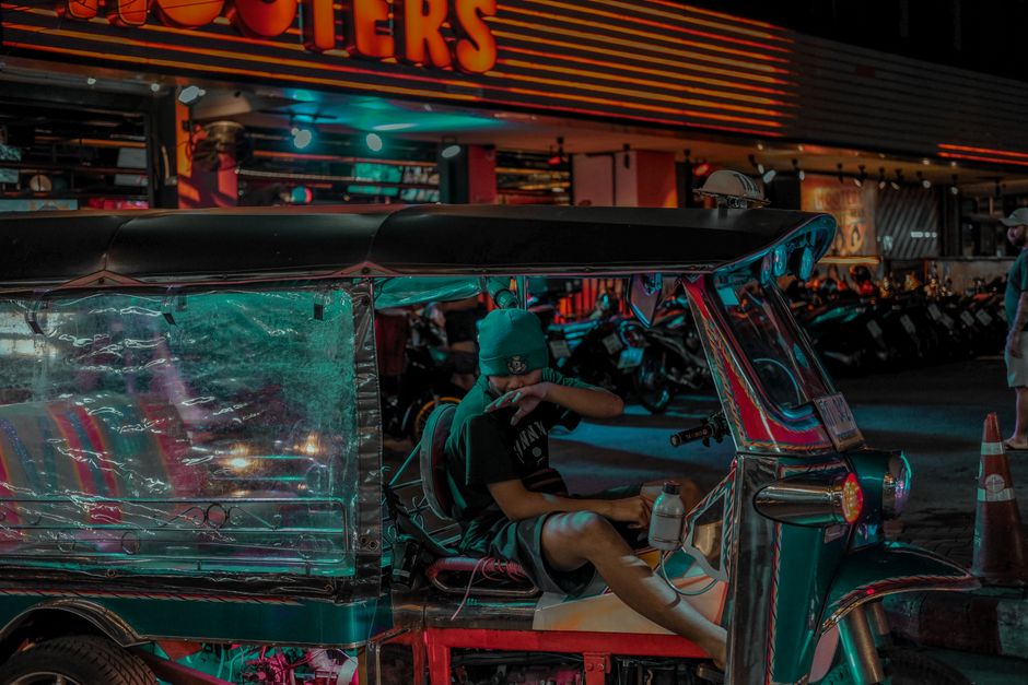 A vibrant tuk-tuk waiting on a bustling street in Phnom Penh, Cambodia, ready for travelers