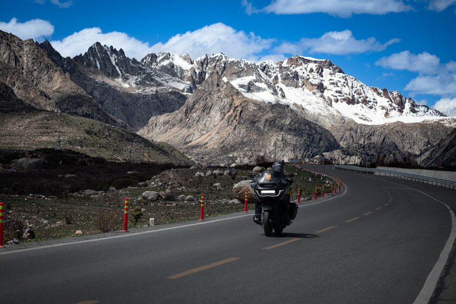 A modern car driving on a scenic highway through a beautiful mountainous landscape in China