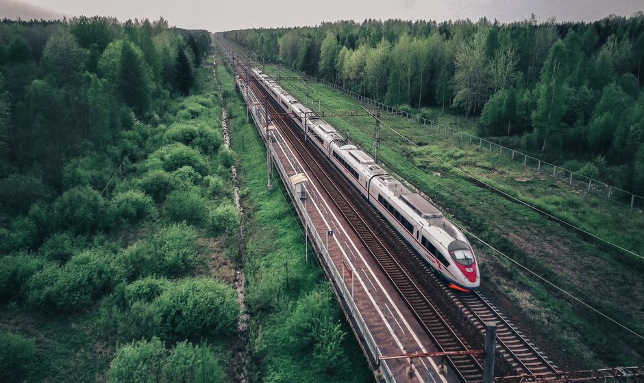 High-speed train in China speeding through a modern city skyline and green fields