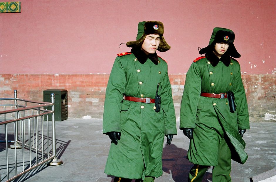 A Chinese police officer assisting a tourist in a busy city square in China, symbolizing safety and assistance.