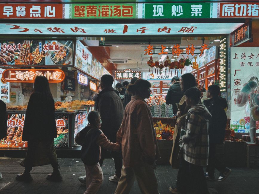 Bustling Nanjing Road in Shanghai, China, with shoppers and bright store signs