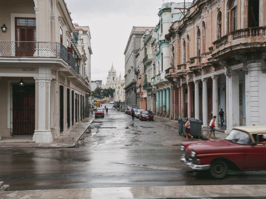 Vibrant street scene in Old Havana, Cuba, with classic cars and colonial architecture, representing travel costs.