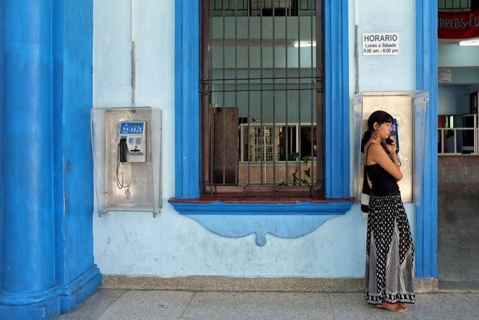 Tourist using a smartphone with an offline map app in a colorful street in Havana, Cuba