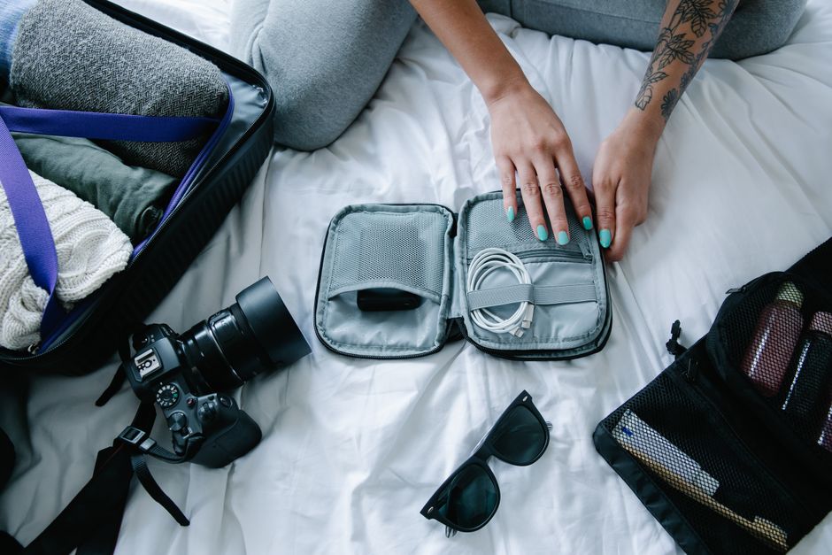 A traveler carefully packing a backpack with essentials for a trip to Cuba