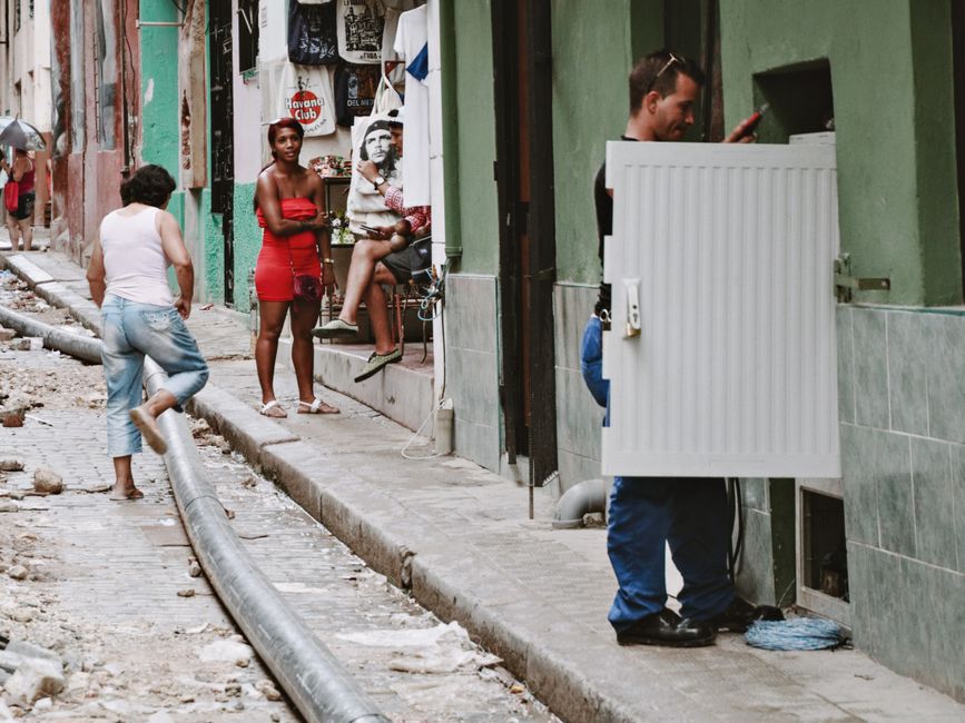 A vibrant street scene in Old Havana, Cuba, with people walking, symbolizing safe exploration.