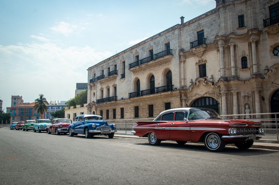 Colorful vintage American car driving down a lively street in Old Havana, Cuba