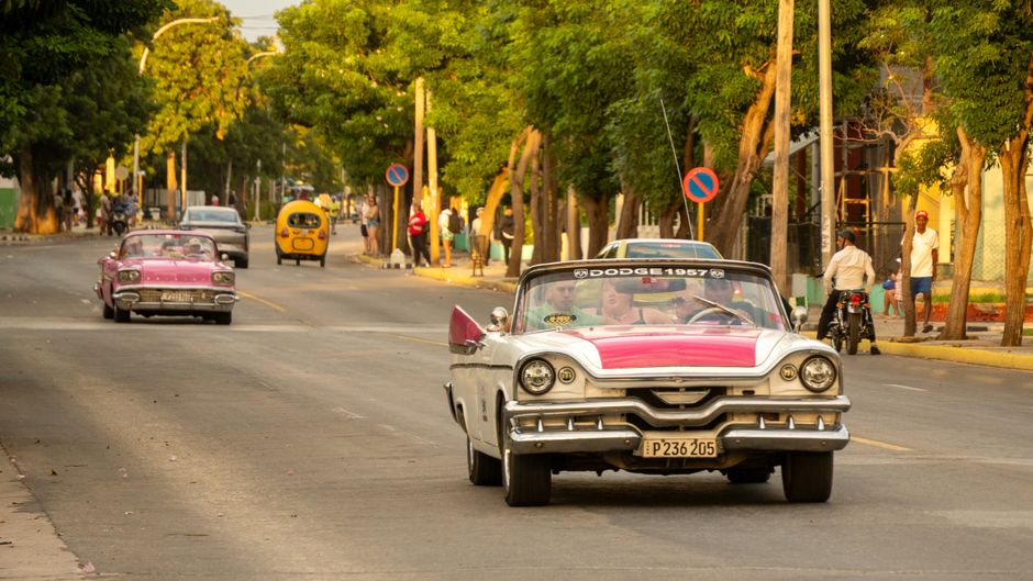 Sunny street in Havana, Cuba with classic cars and vibrant buildings