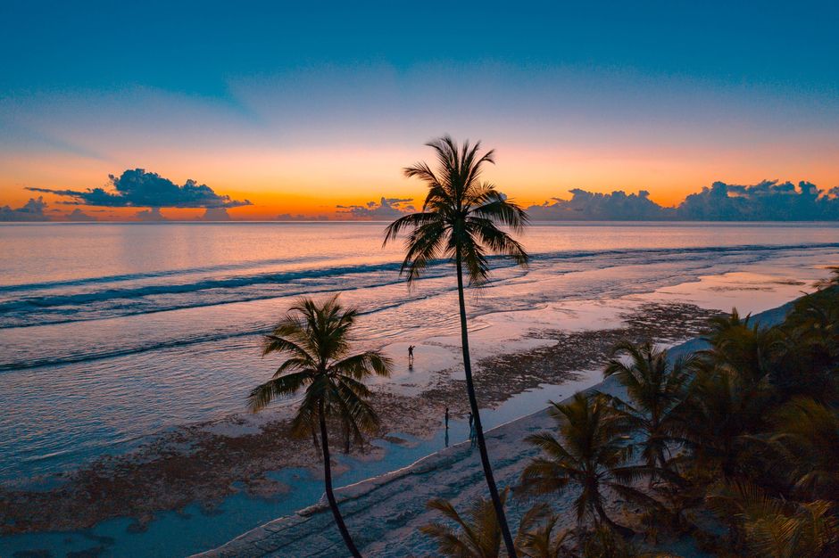 Couple relaxing on a beautiful Jamaican beach at sunset, symbolizing worry-free travel with insurance