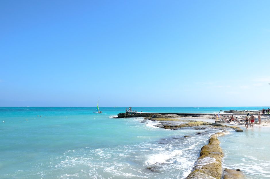 Sunny white sand beach in Montego Bay, Jamaica with clear turquoise water