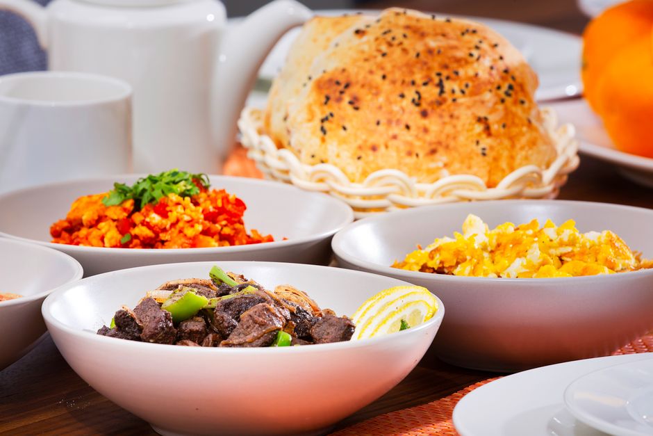 A bowl of traditional Maldivian Garudhiya fish broth with rice and side dishes on a table in the Maldives