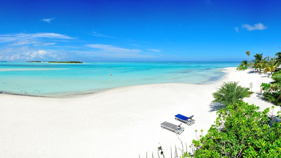 A tranquil beach in the Maldives with clear turquoise water, symbolizing a safe and peaceful travel experience.