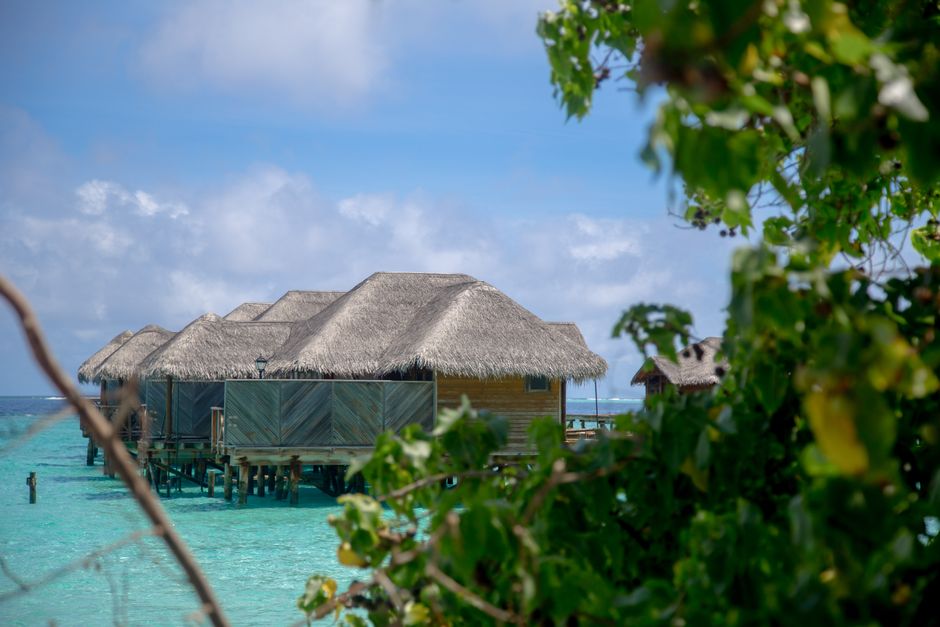 Overwater bungalows stretching into clear turquoise waters at a luxury resort in the Maldives, symbolizing a protected dream vacation.