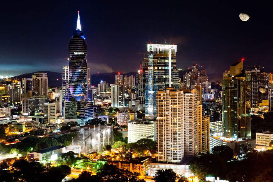 Vibrant Panama City skyline with modern buildings and ocean at sunset, showcasing the country's dynamic atmosphere.