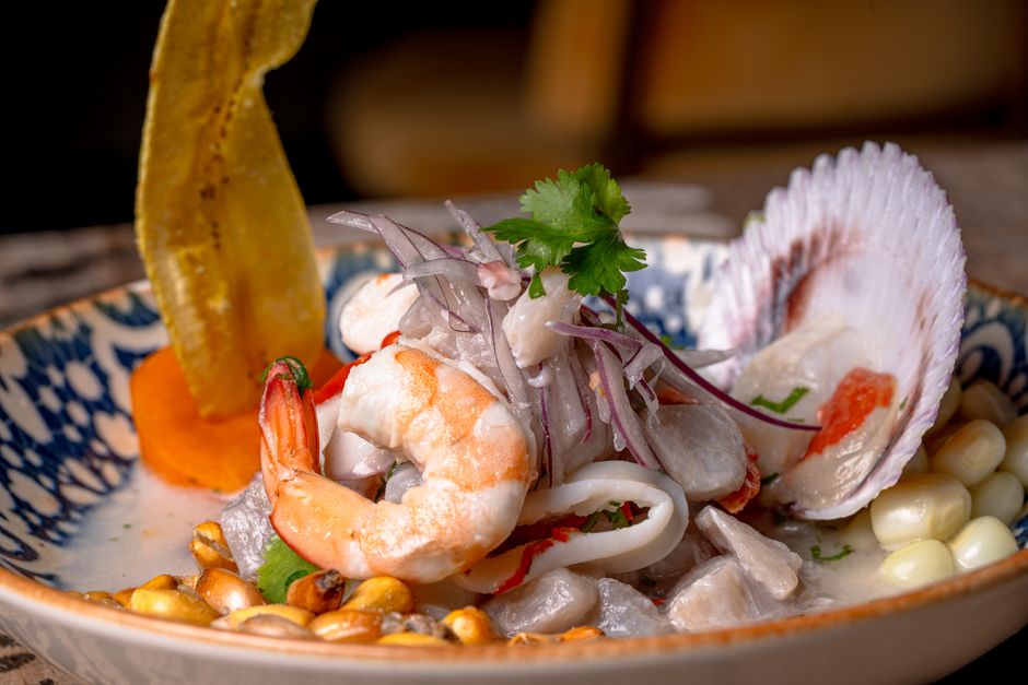 A vibrant plate of traditional Peruvian ceviche with fresh seafood, red onion, and corn, a national dish of Peru